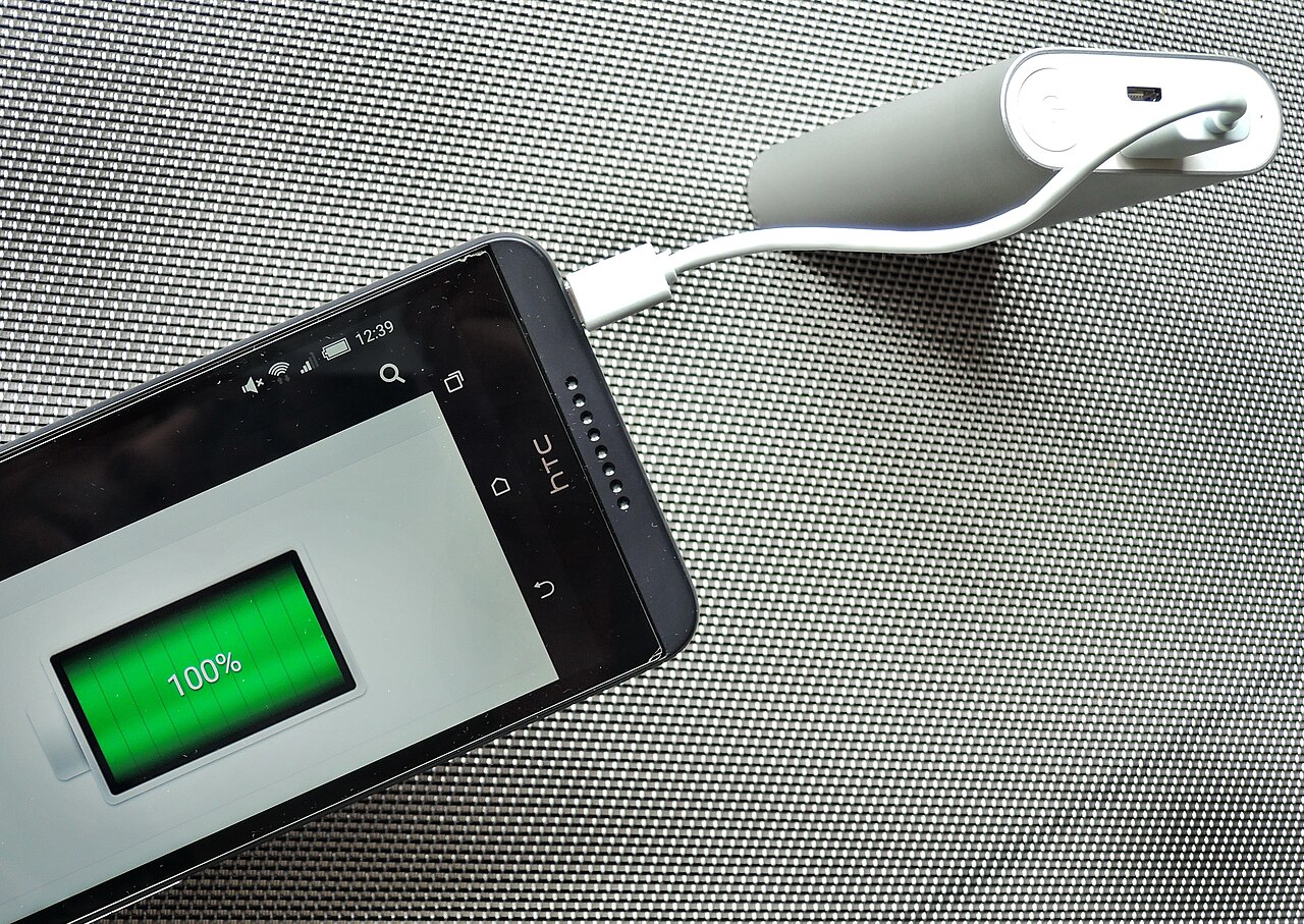 A smartphone being charged from a USB power bank